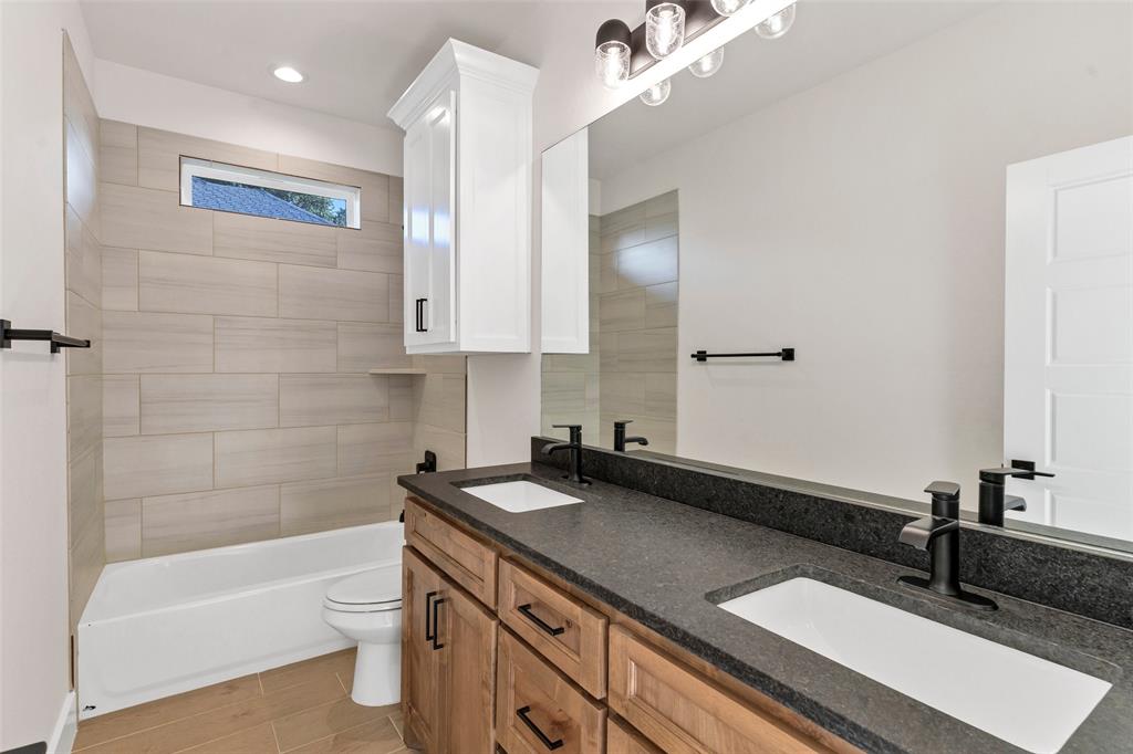 3306 Promenade Court Granbury, TX 76049 - Photo 29 of 40 a bathroom with a sink a large mirror and a bathtub