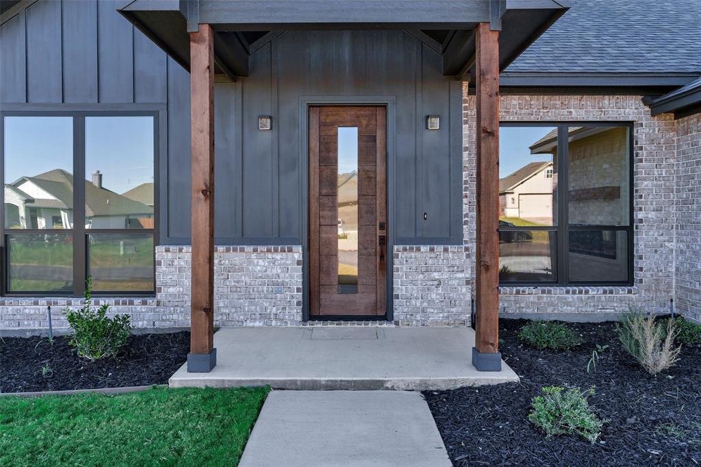 3306 Promenade Court Granbury, TX 76049 - Photo 4 of 40 a front view of a house with a garden