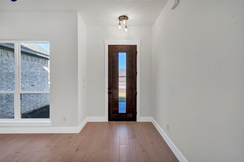 3306 Promenade Court Granbury, TX 76049 - Photo 5 of 40 an empty room with wooden floor and windows