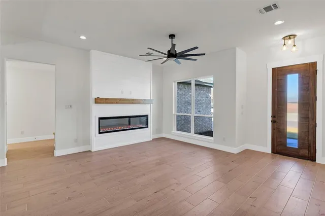 a view of an empty room with a fireplace and a window