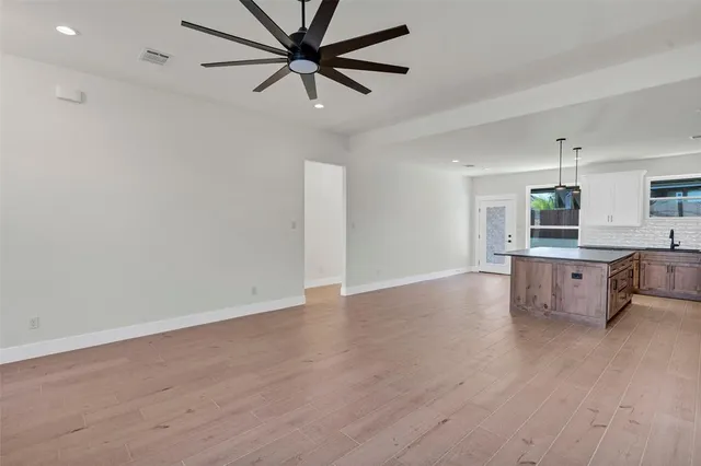 a view of a kitchen with a sink and dishwasher a refrigerator with wooden floor