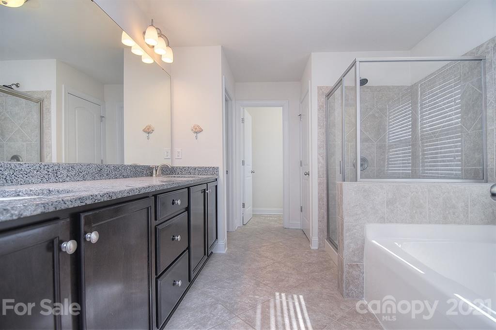 2001 Fallondale Road Waxhaw, NC 28173 - Photo 14 of 36 a bathroom with a granite countertop sink a bathtub and shower