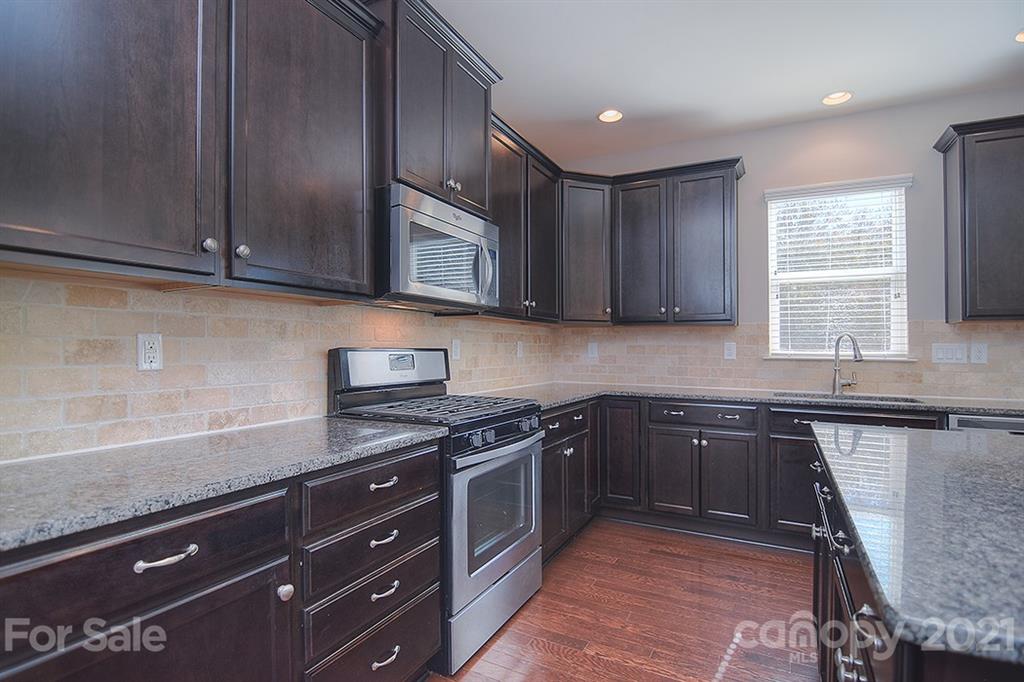 2001 Fallondale Road Waxhaw, NC 28173 - Photo 27 of 36 a kitchen with granite countertop wooden cabinets and a stove top oven