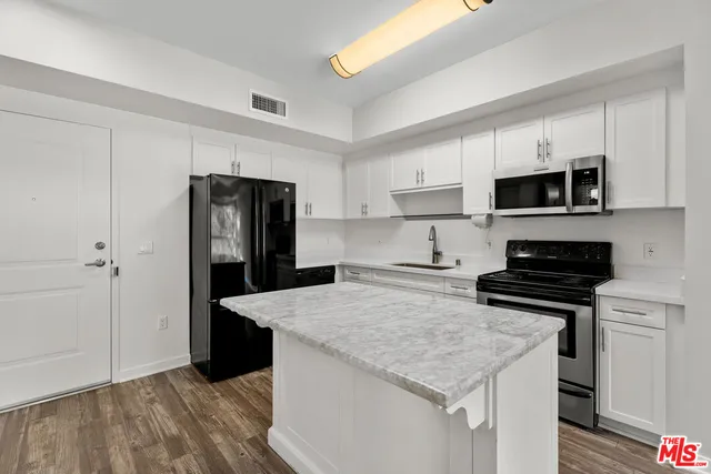 a kitchen with a stove a refrigerator and a microwave