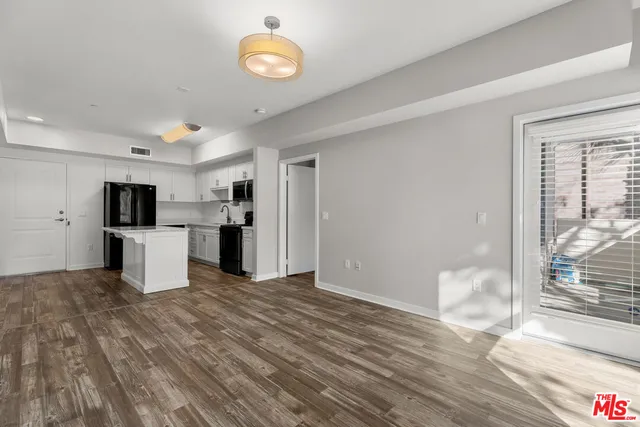 a view of a kitchen with wooden floor and a refrigerator
