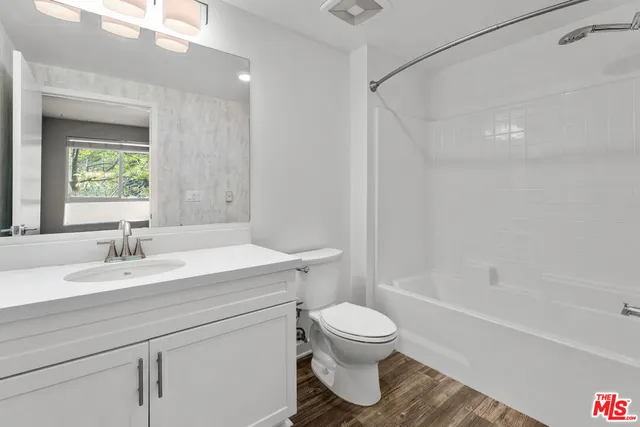 a bathroom with a sink toilet vanity and tub