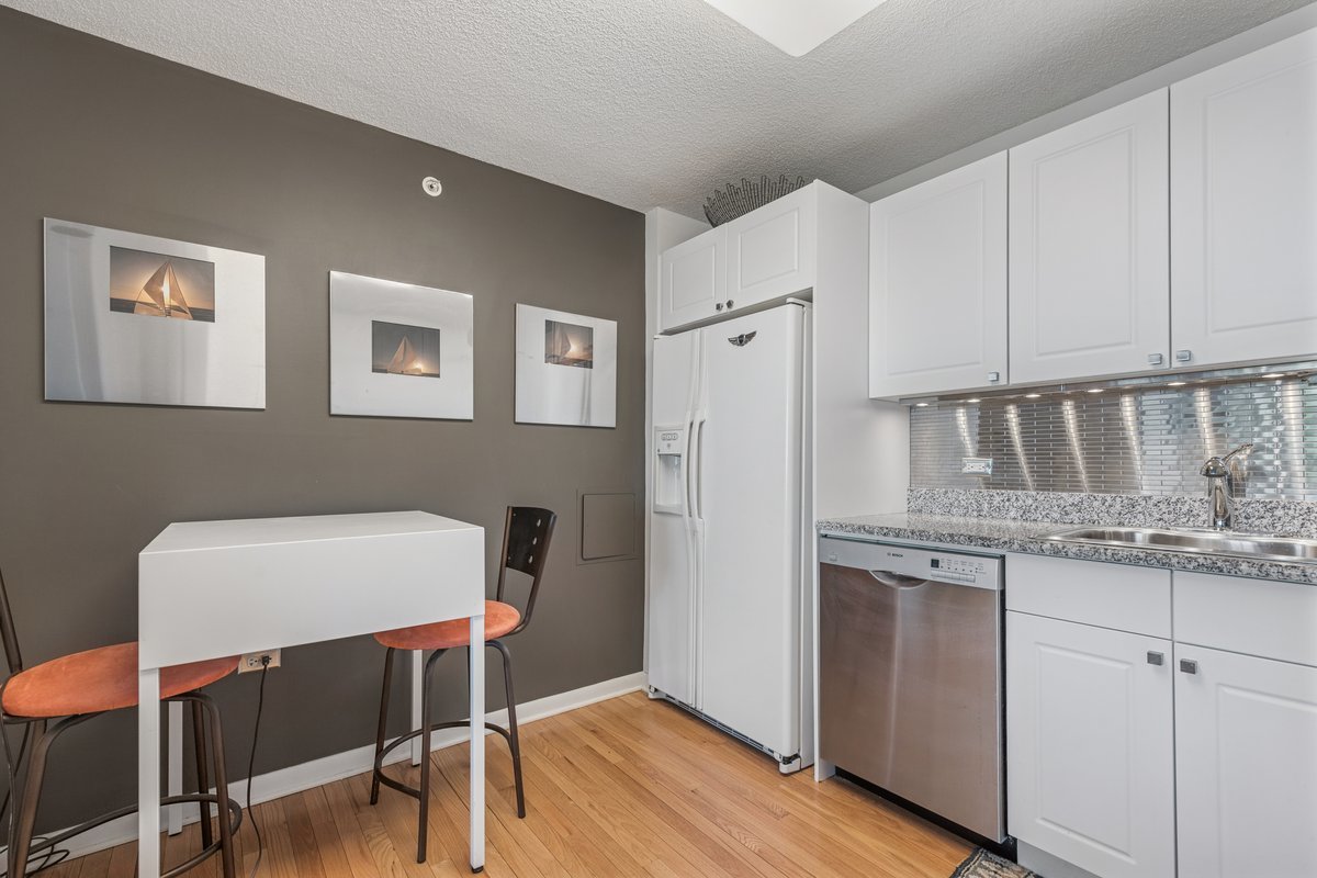 800 Elgin Road, Unit 909 Evanston, IL 60201 - Photo 9 of 15 a kitchen with stainless steel appliances granite countertop a stove a refrigerator a white table and chairs