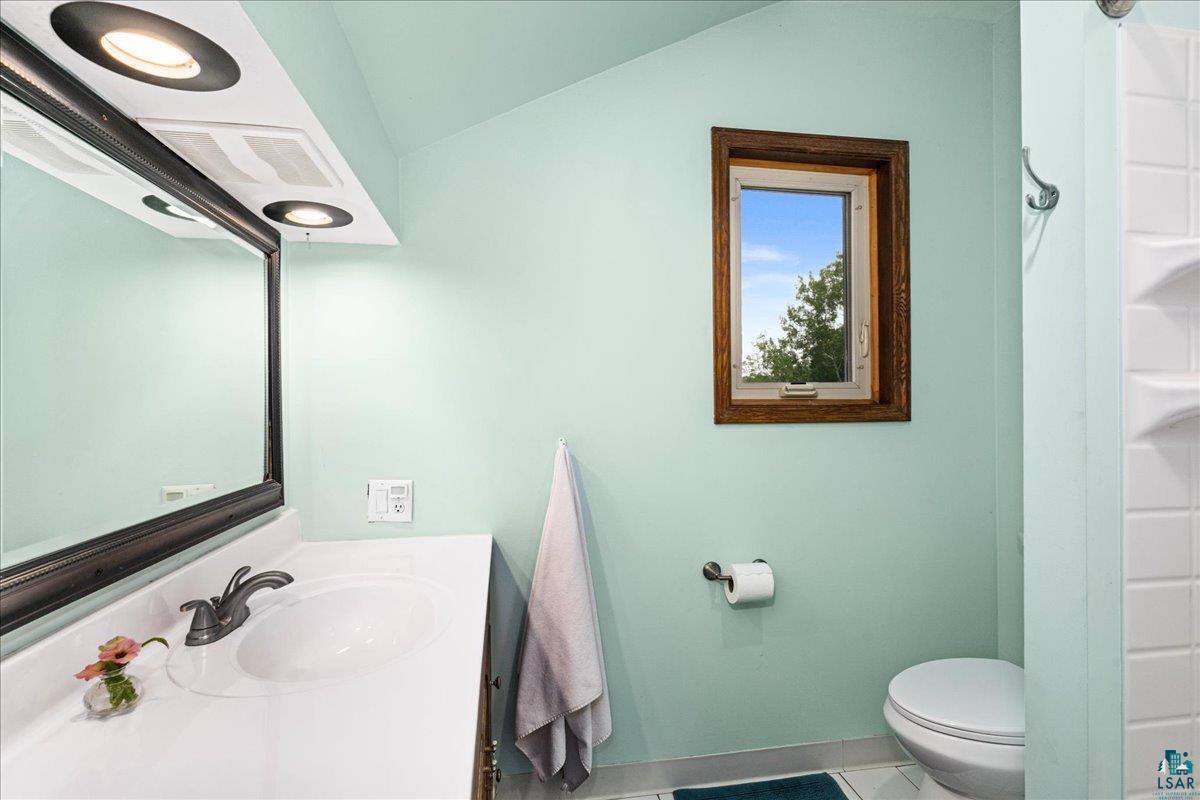 5195 Lavaque Junction Road Hermantown, MN 55811 - Photo 29 of 66 Bathroom featuring a white vanity with integrated sink, dark bronze faucet, and framed mirror with recessed lighting