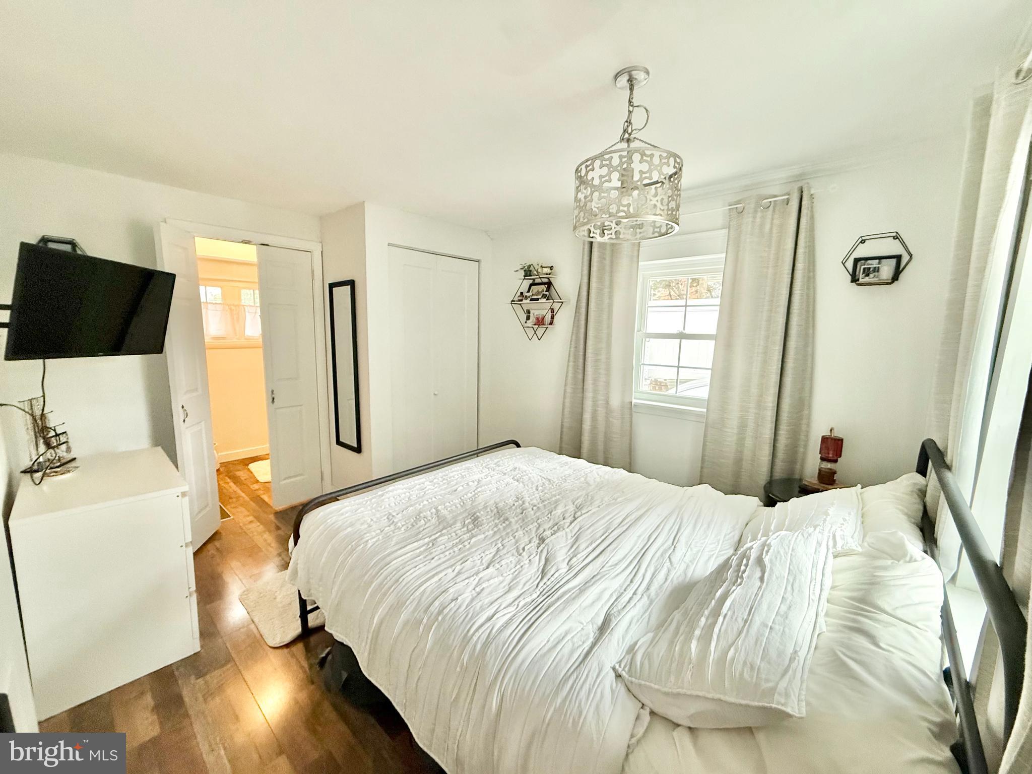 1303 Bruce Road Oreland, PA 19075 - Photo 11 of 13 a bedroom with a bed and a chandelier