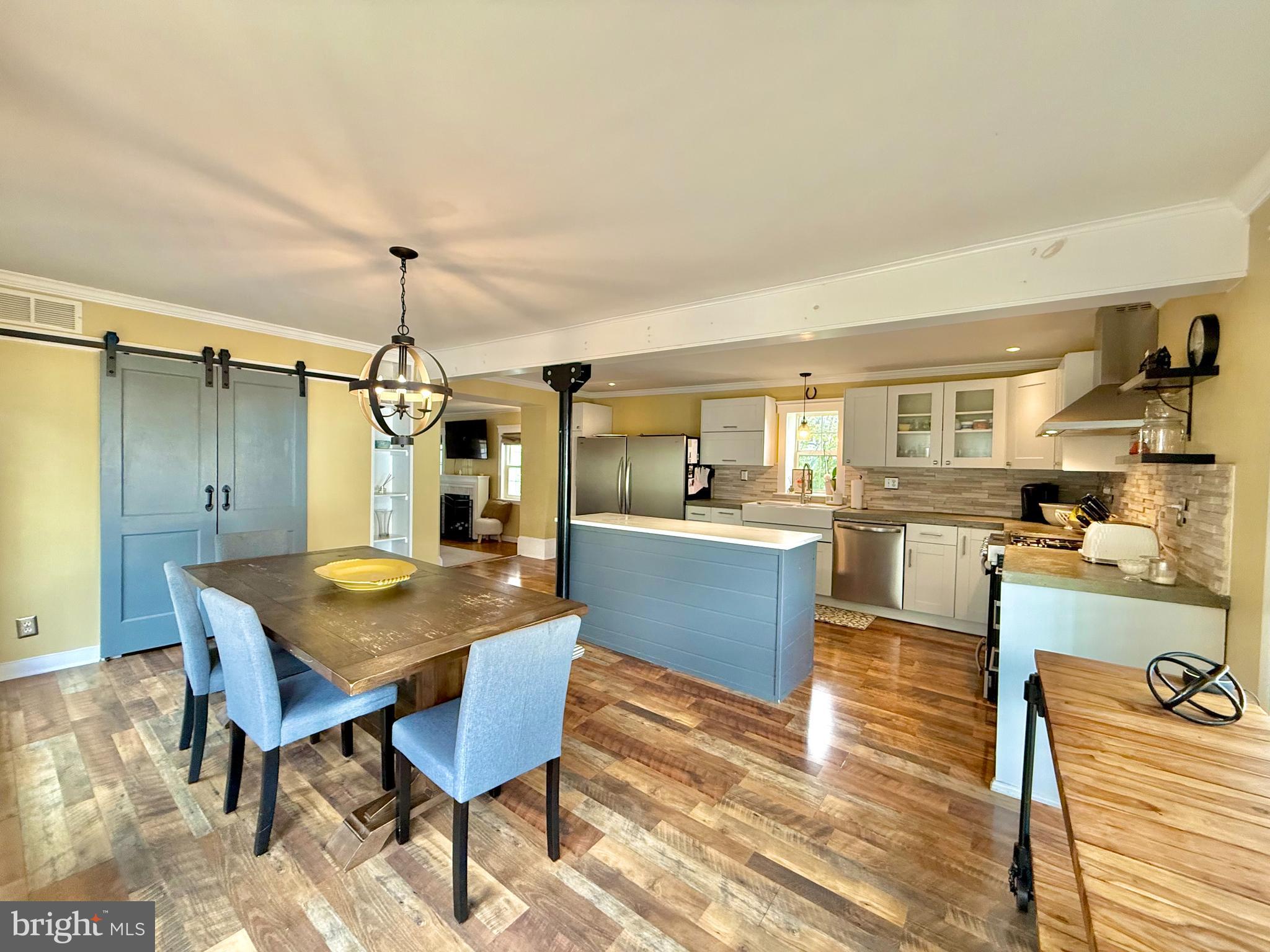1303 Bruce Road Oreland, PA 19075 - Photo 6 of 13 a view of a dining room and livingroom with furniture wooden floor a rug a painting and a chandelier