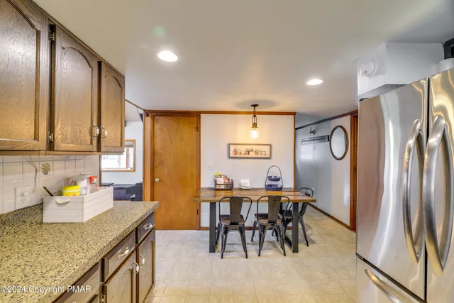 a kitchen with stainless steel appliances granite countertop a refrigerator and a stove top oven