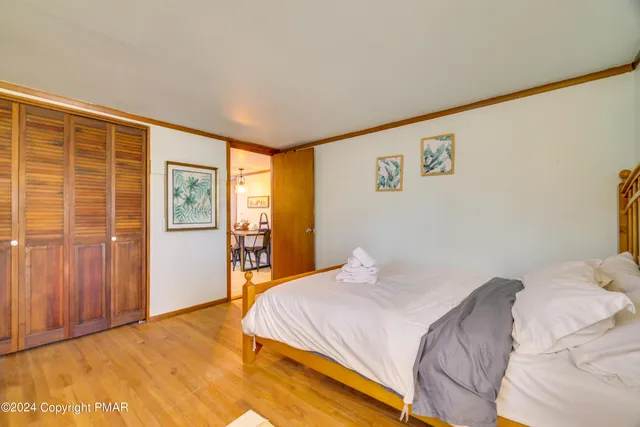 a bedroom with a bed and wooden floor