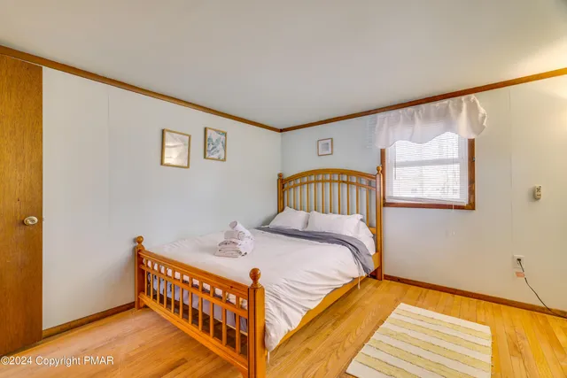 a bedroom with a bed and wooden floor
