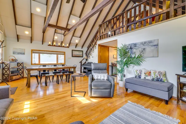 a living room with furniture floor to ceiling window and wooden floor
