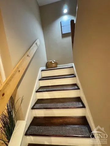 a kitchen with stainless steel appliances granite countertop a sink a stove top oven a chimney cabinets and a dining table