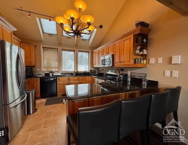 a large kitchen with stainless steel appliances granite countertop a refrigerator a stove a sink dishwasher with a dining table and chairs