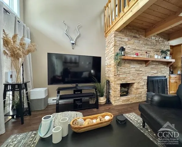 a living room with furniture a fireplace and a floor to ceiling window