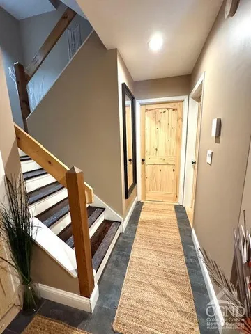 a view of a hallway with wooden floor and staircase