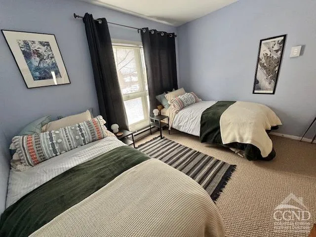 a bedroom with a bed and a couch next to a window