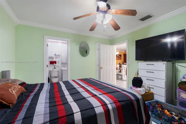 a bedroom with a bed and a flat tv screen on the dresser