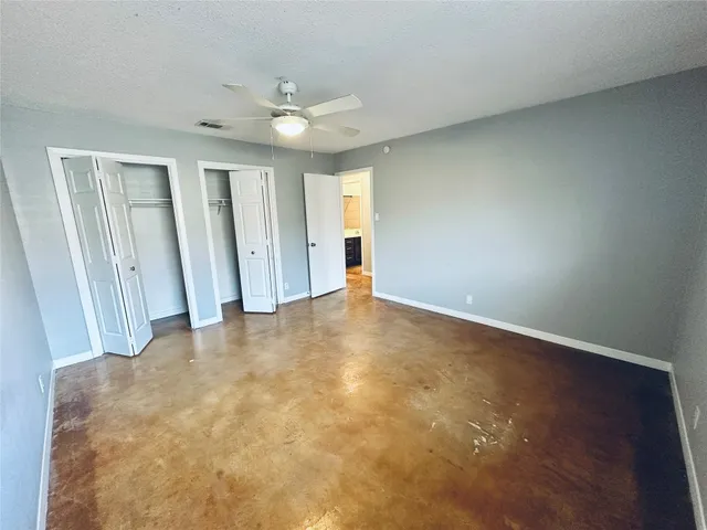 an empty room with an entryway and fan