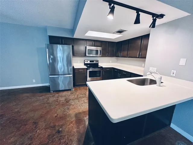 a kitchen with kitchen island white cabinets and refrigerator