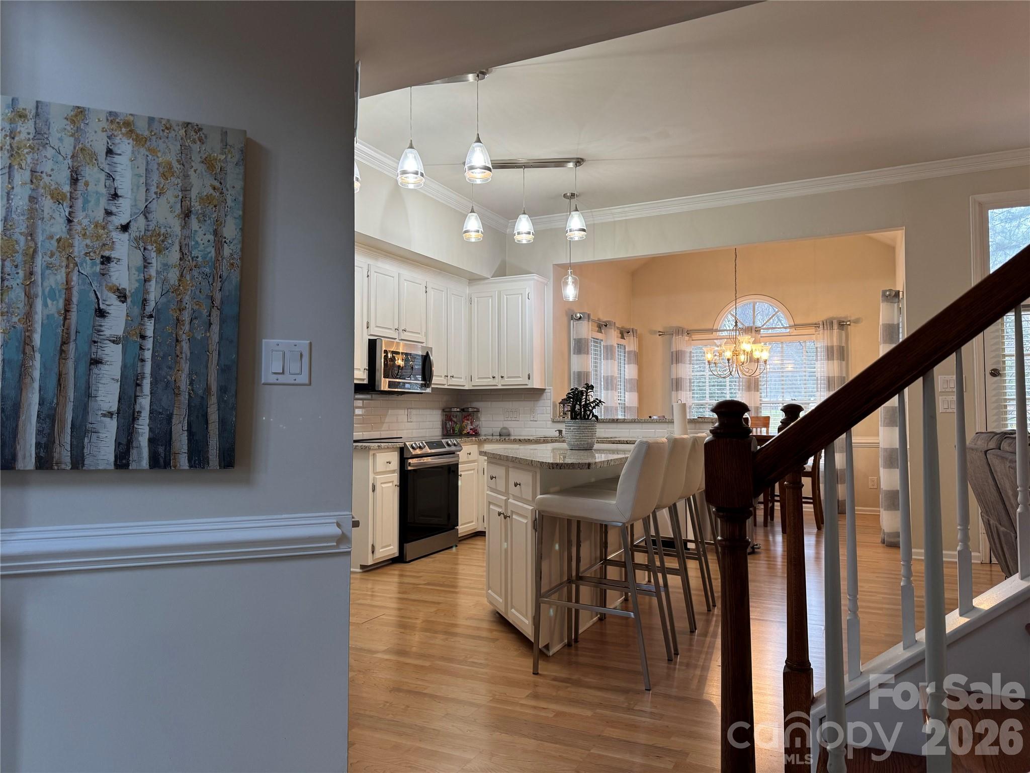4846 Fortunes Ridge Trail Charlotte, NC 28269 - Photo 11 of 43 a kitchen with stainless steel appliances kitchen island granite countertop a table chairs and a refrigerator