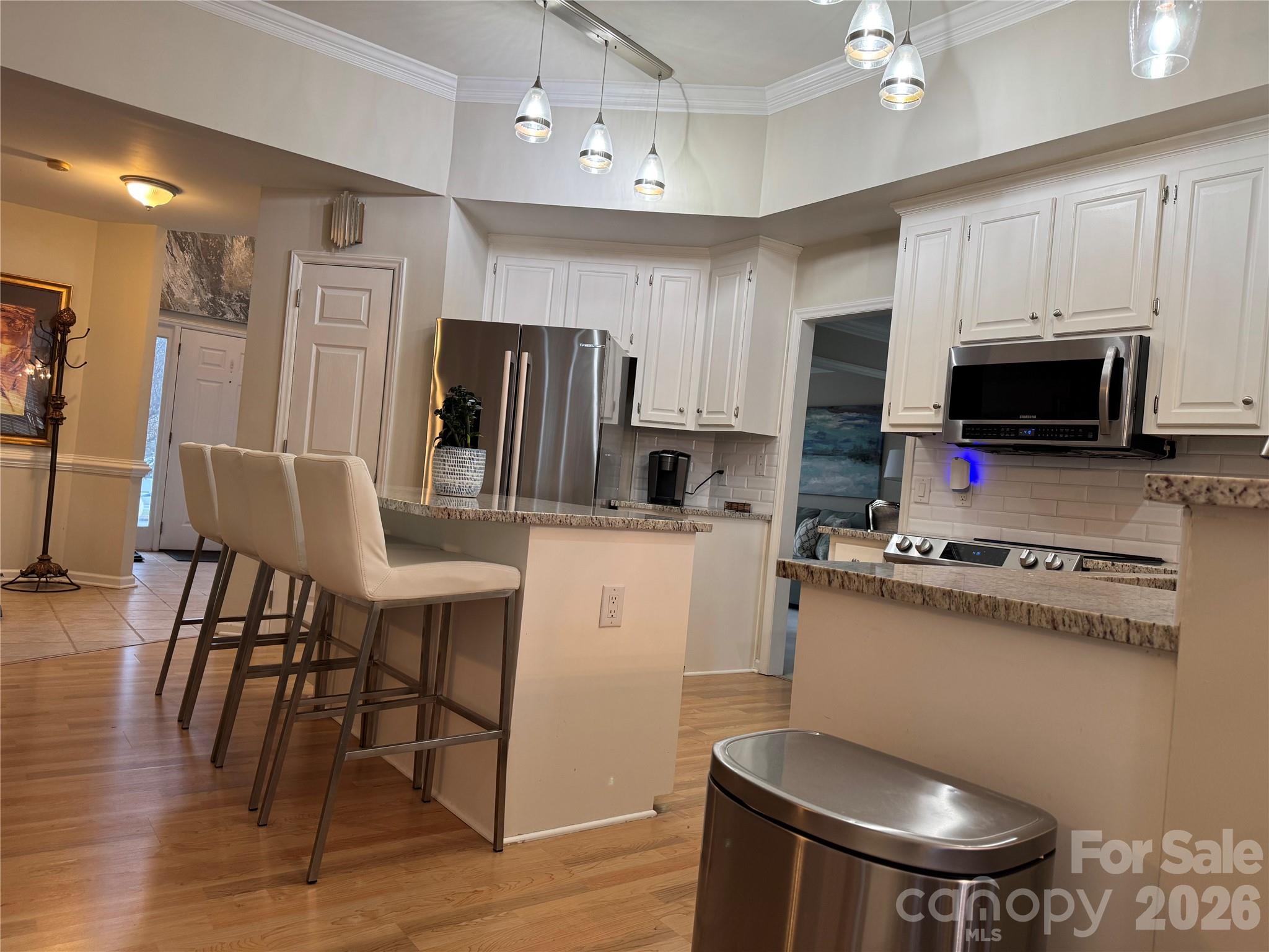 4846 Fortunes Ridge Trail Charlotte, NC 28269 - Photo 12 of 43 a kitchen with stainless steel appliances a dining table chairs stove refrigerator and cabinets