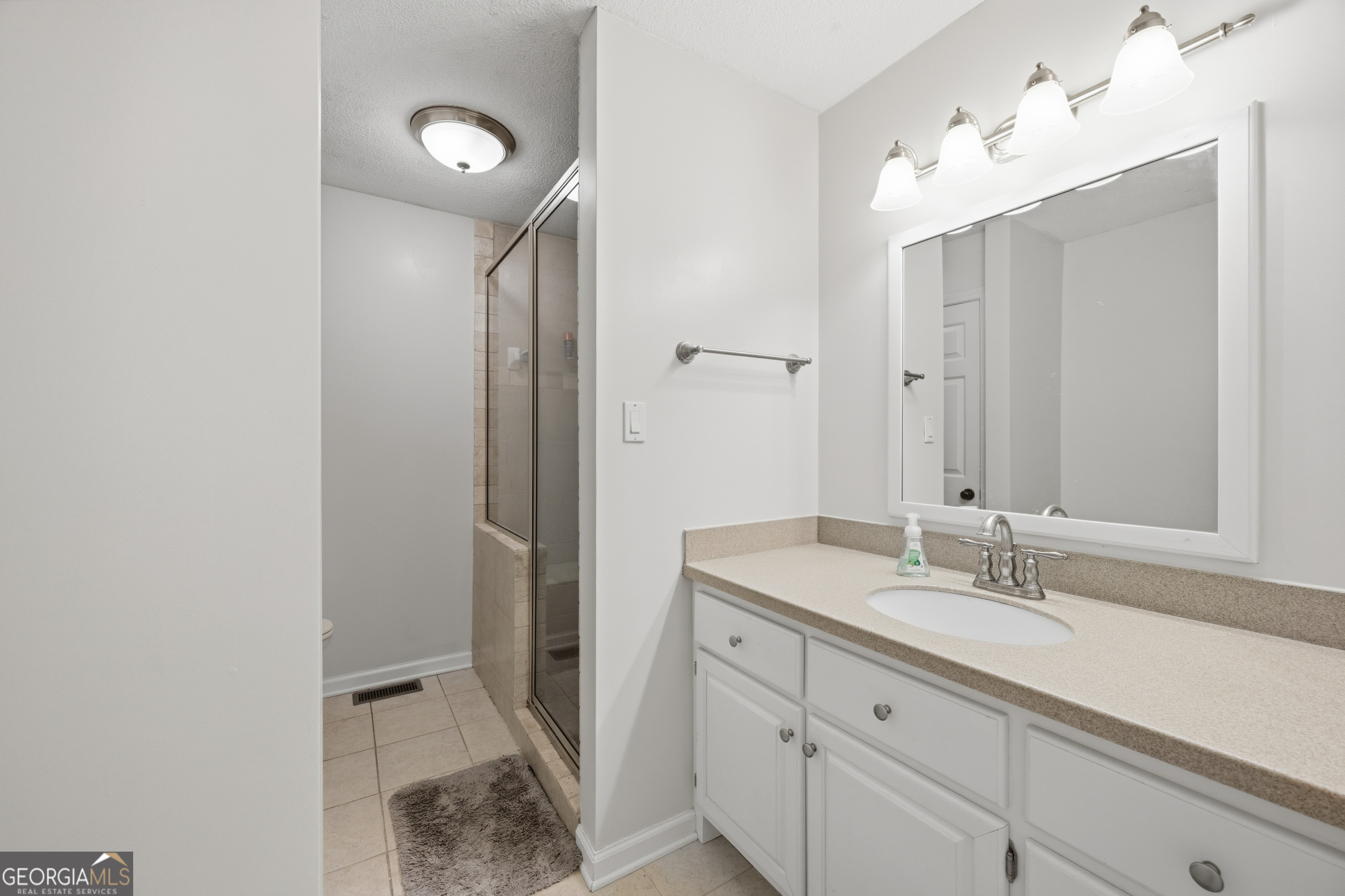 3773 Trophy Place Lizella, GA 31052 - Photo 17 of 32 a spacious bathroom with a granite countertop sink and a mirror