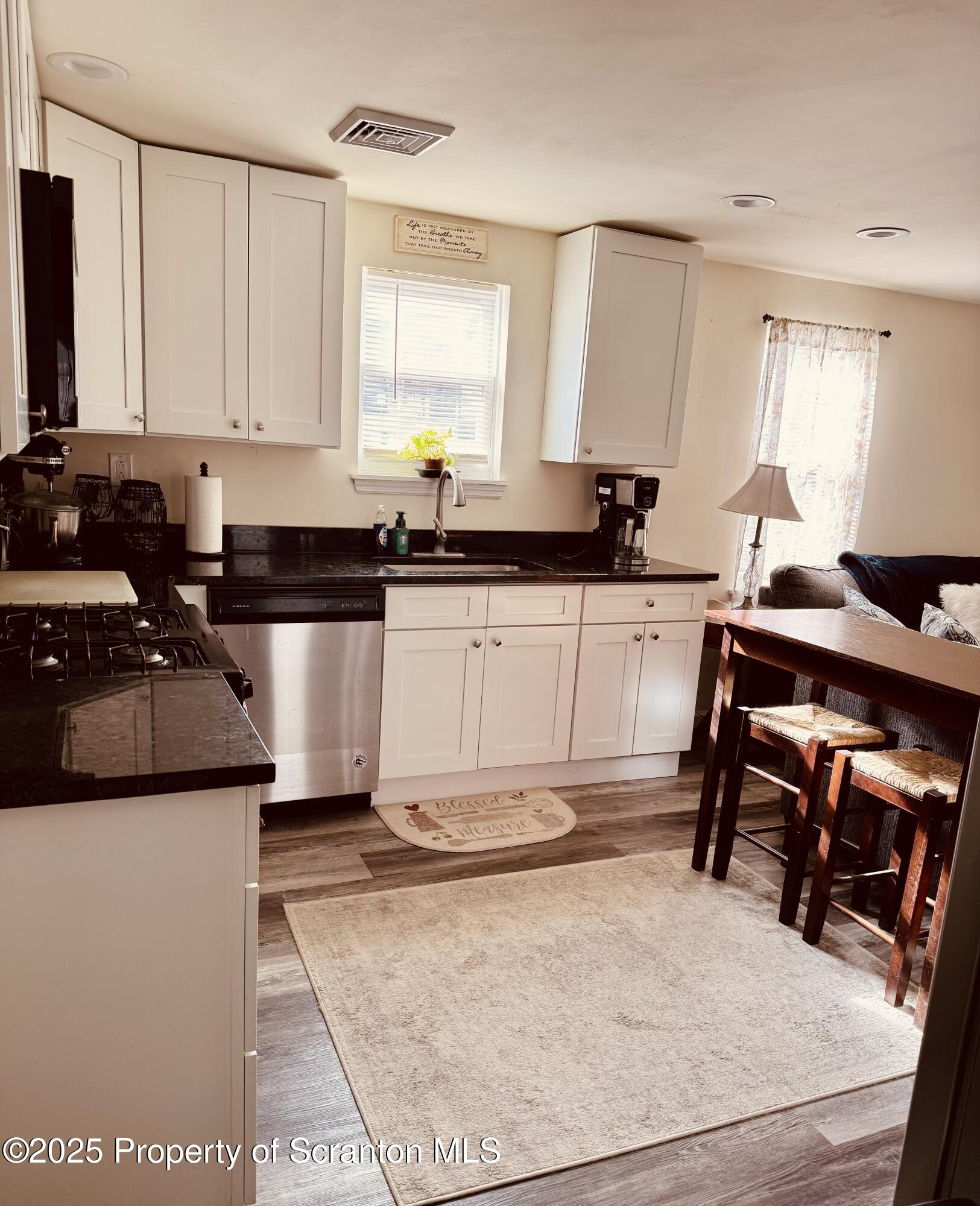 a kitchen with stainless steel appliances granite countertop a stove a sink and a refrigerator