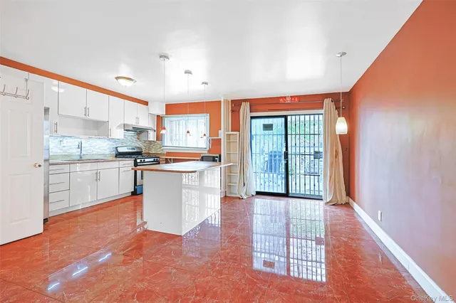 a kitchen with stainless steel appliances granite countertop a refrigerator oven a sink and white cabinets