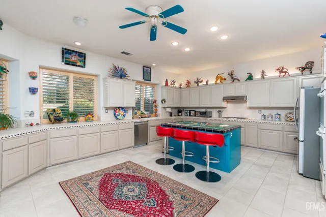 a kitchen with granite countertop a table chairs stove and cabinets