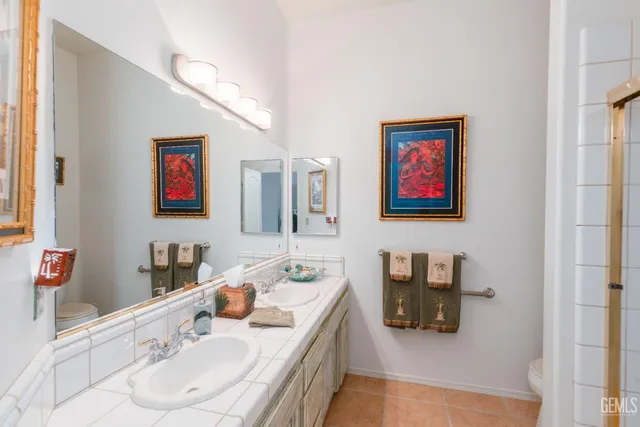 a bathroom with a sink and mirror with toilet