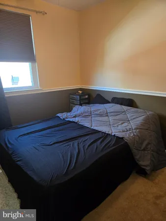 a bed sitting in a bedroom next to a window