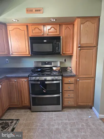 a kitchen with granite countertop a stove and a refrigerator