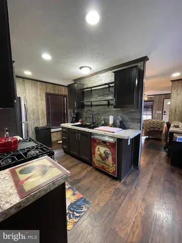 a kitchen with stainless steel appliances kitchen island granite countertop a stove and a sink