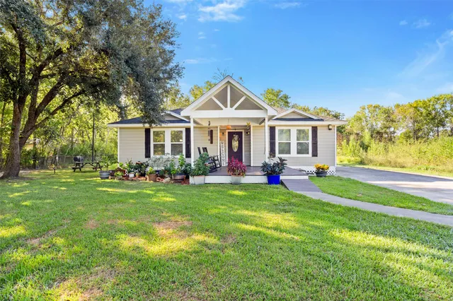 a front view of a house with a yard and trees