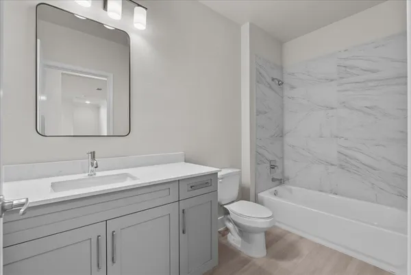 a bathroom with a toilet a sink a bathtub and a mirror