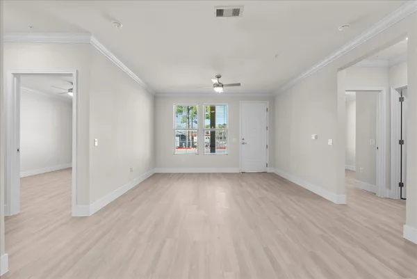 an empty room with wooden floor and windows