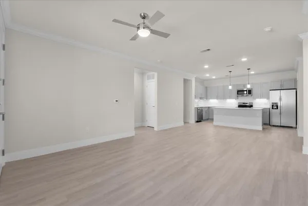a view of an empty room with a kitchen