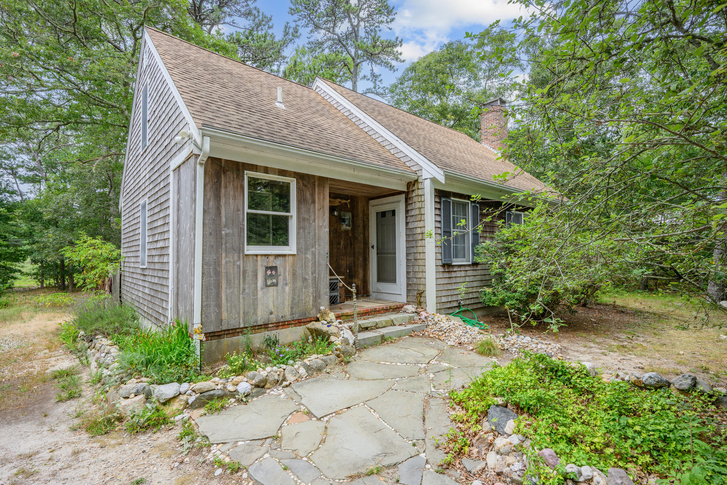 153 Red Fawn Road Brewster, MA 02631 - Photo 2 of 28 a view of brick house with a large windows plants and large trees