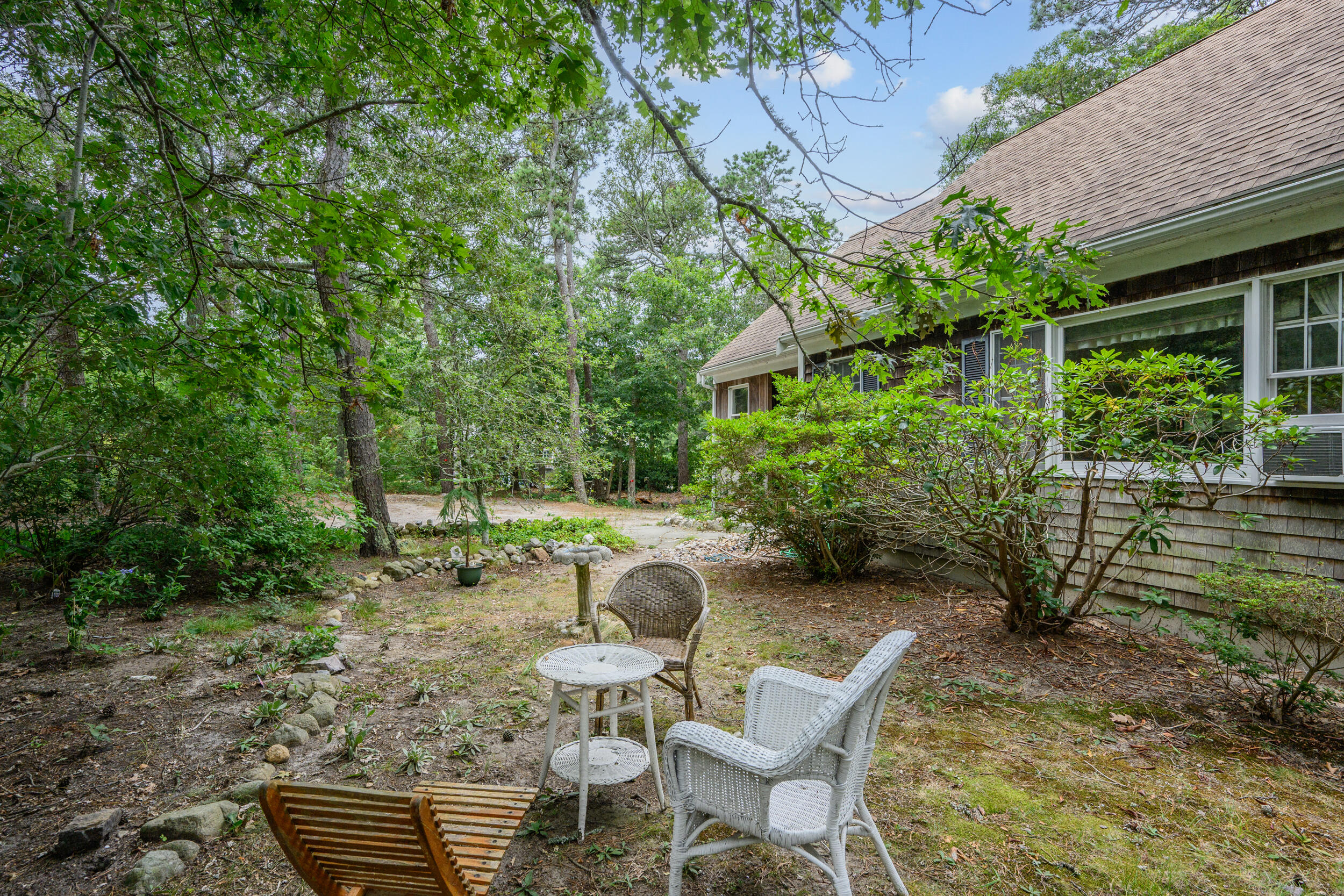 153 Red Fawn Road Brewster, MA 02631 - Photo 27 of 28 a backyard of a house with fountain table and chairs