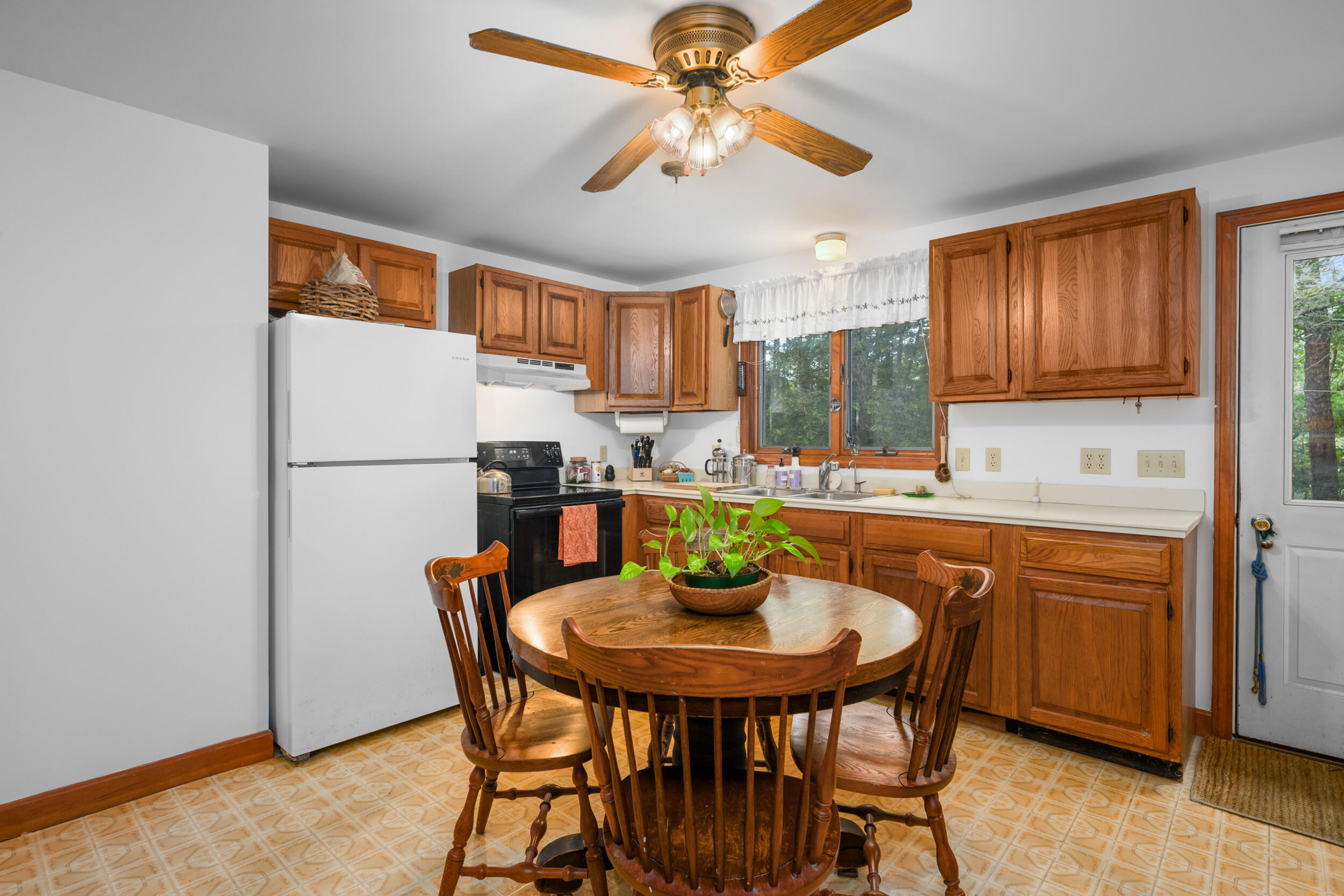 153 Red Fawn Road Brewster, MA 02631 - Photo 8 of 28 a kitchen with stainless steel appliances granite countertop a dining table chairs and a refrigerator