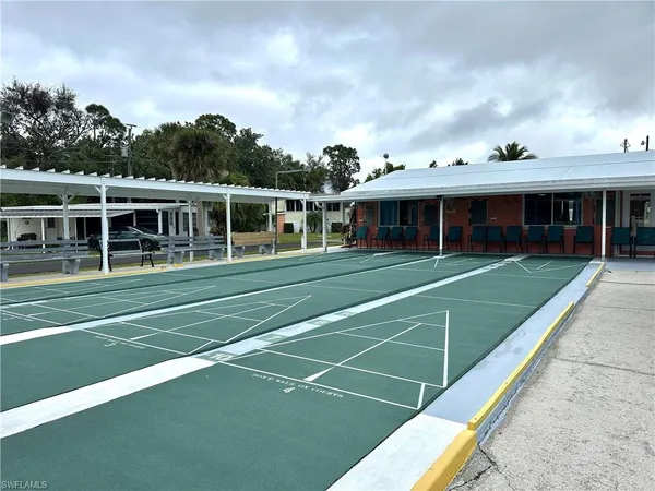 a view of a white building with a big yard