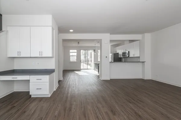 a view of a kitchen with wooden floor and electronic appliances