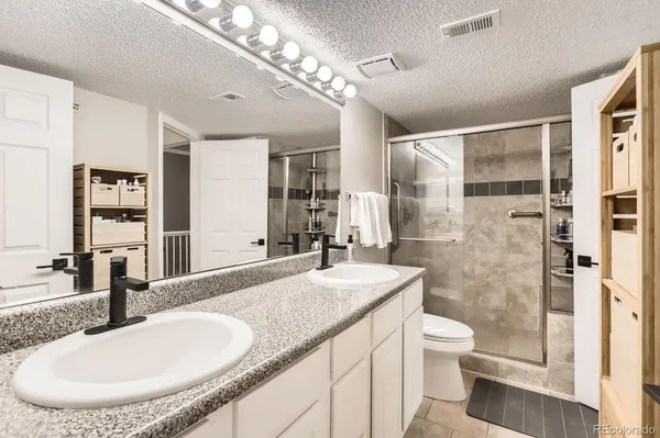 a en suite bathroom with a double vanity sink and a mirror