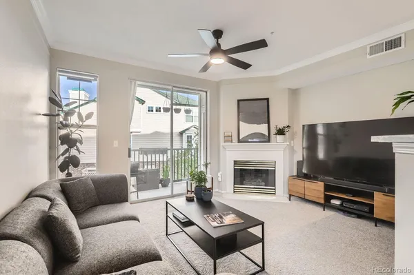 a living room with furniture a flat screen tv and a fireplace