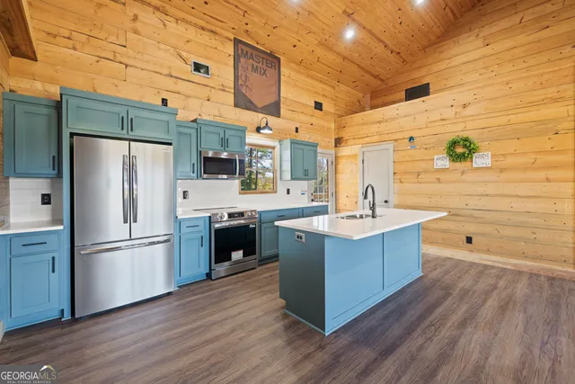 a kitchen with stainless steel appliances a sink cabinets and wooden floor