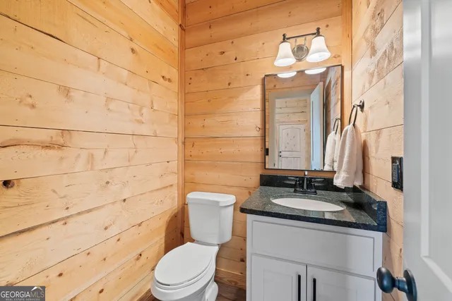 a bathroom with a granite countertop toilet sink and mirror