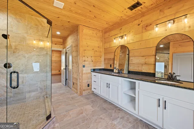 a bathroom with a double vanity sink mirror and shower